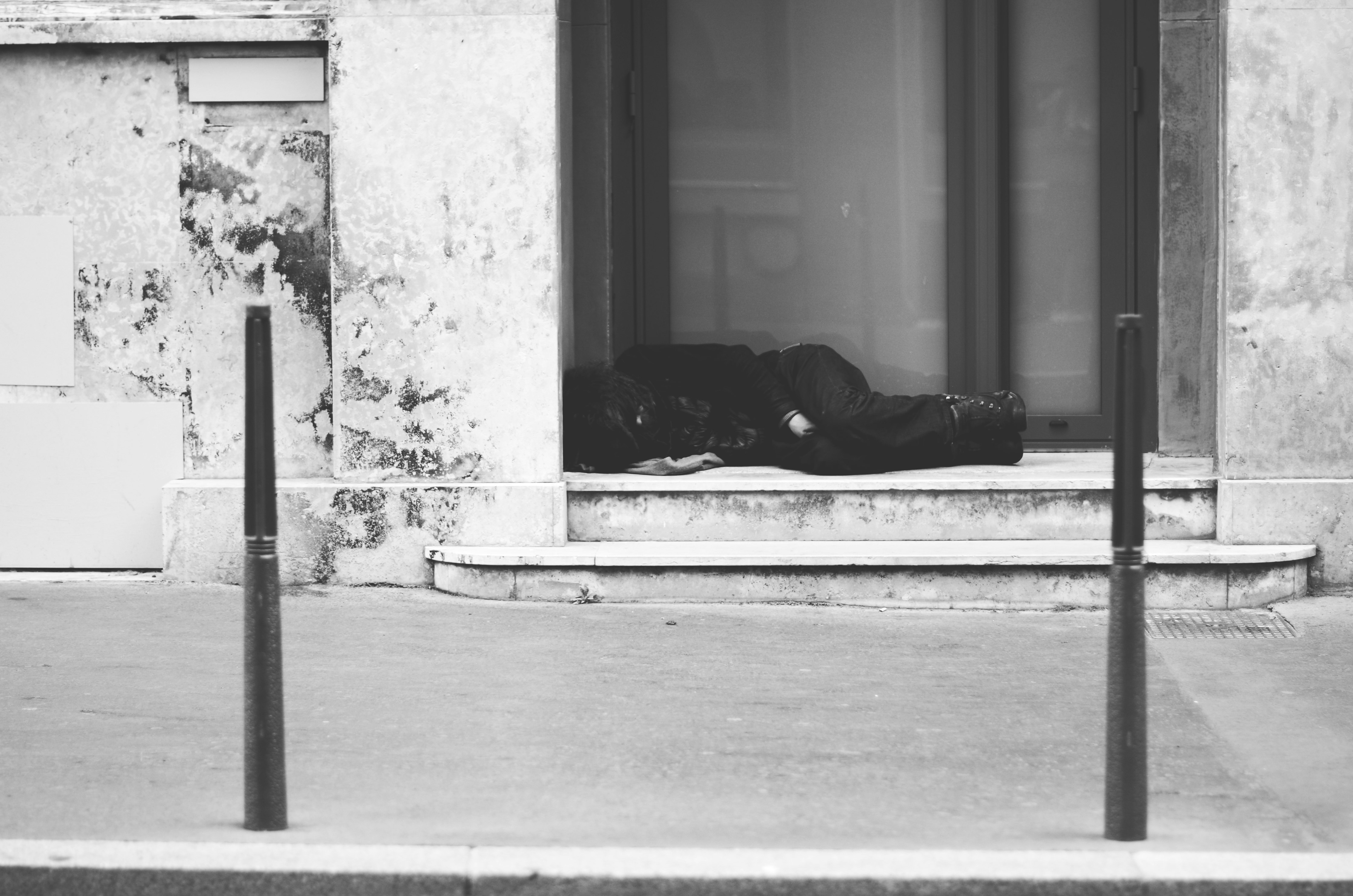 grayscale photo of man lying on floor